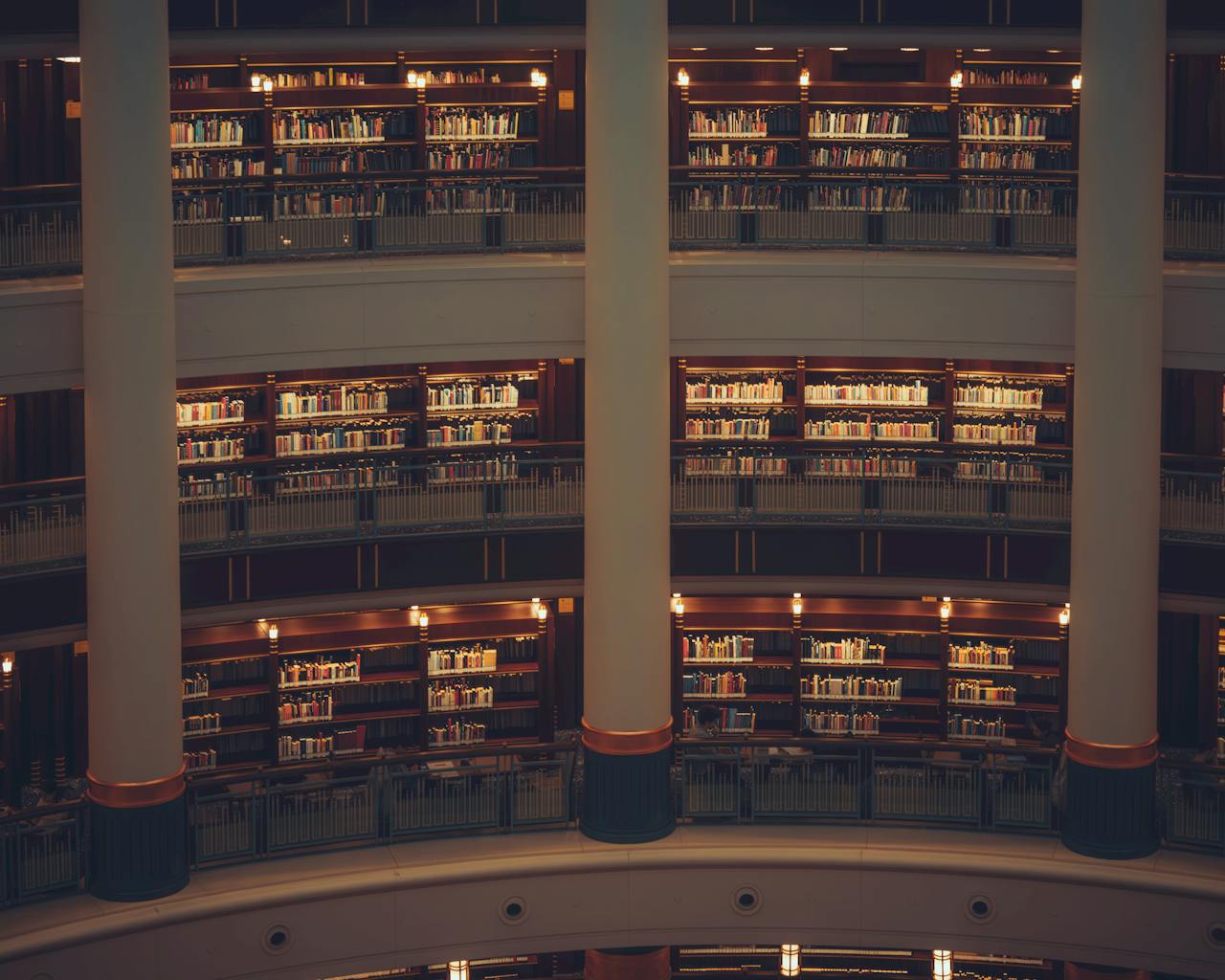 A cozy, multi-level library environment featuring warmly lit bookshelves.
